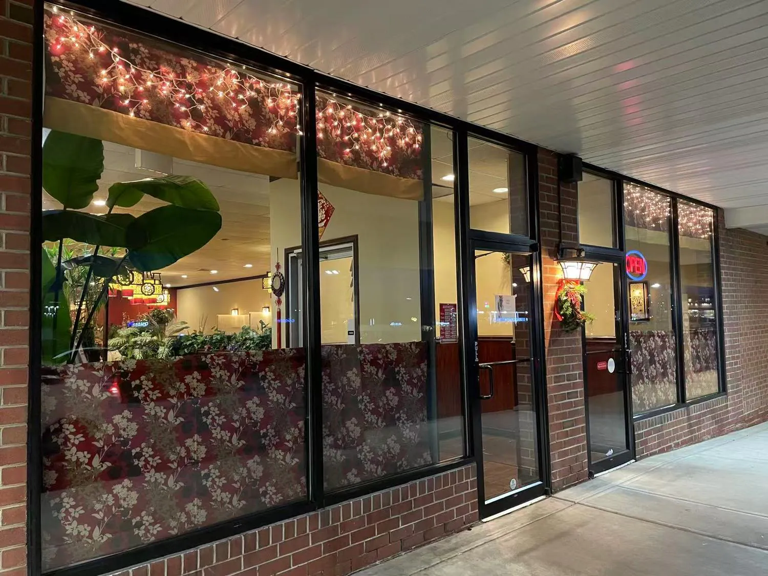 Warmly lit side entrance with festive string lights at Forbidden City Chinese Restaurant in Westminster